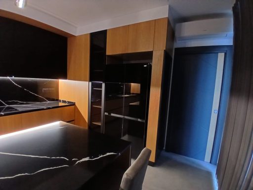 Interno moderno di una cucina con mobili in legno scuro e piano in granito nero.